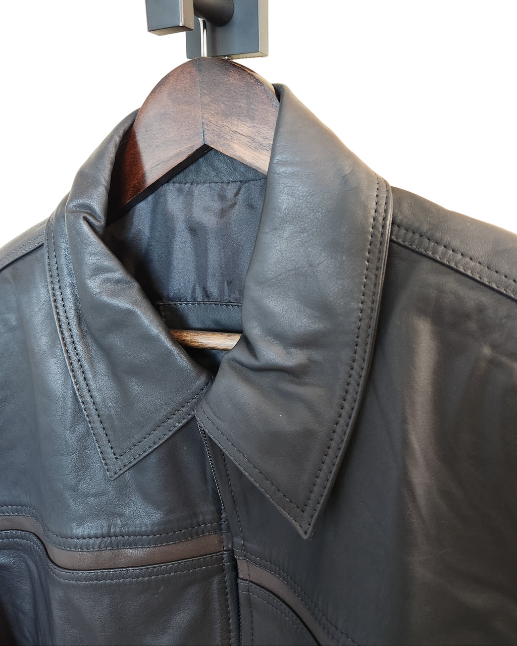 Close-up of a leather jacket with a wooden handle attached to a door